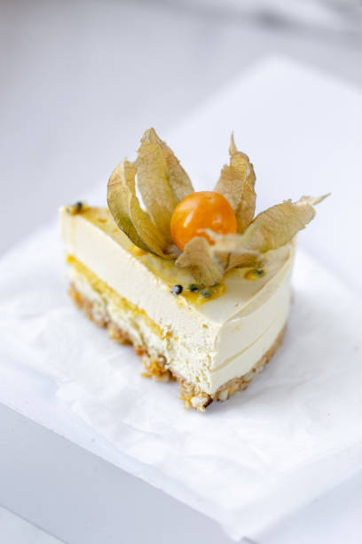 Passionfruit vegan cheesecake with Physalis on marble background with copy space