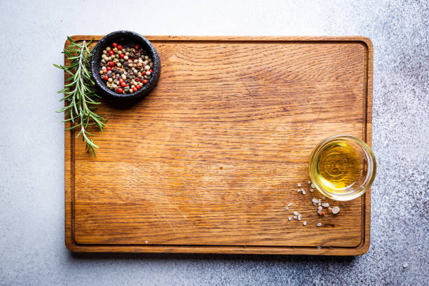 Cutting board and seasonings Cutting board, seasonings and oil set on dark background, top view, copy space black peppercorn photos stock pictures, royalty-free photos & images