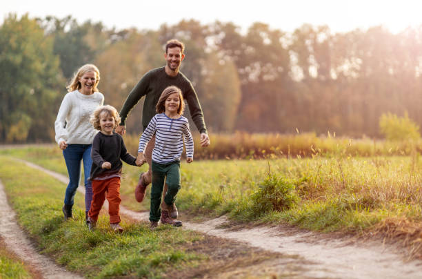 giovane famiglia che si diverte all'aperto - family happiness outdoors autumn foto e immagini stock