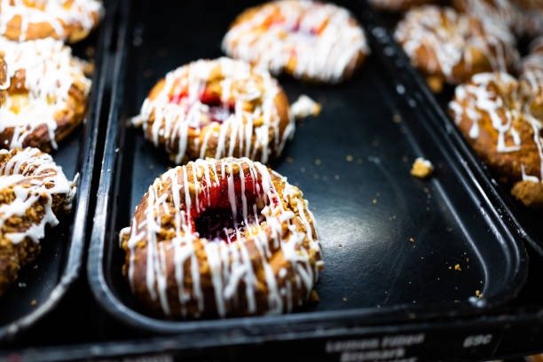 istock White glaze iced danish pastry fried donuts with red purple raspberry jam on tray in fresh bakery store shop closeup 1182907699