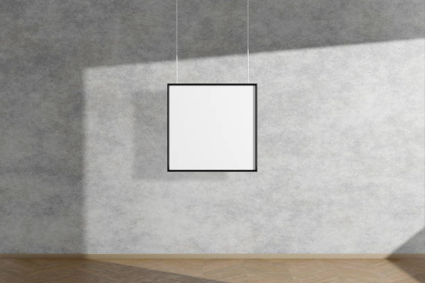 istock Square mock up picture frame in black hanging on concrete wall simple interior dark room light and shadow of the window. 3D rendering 1182908418