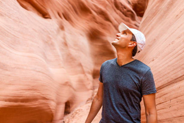 caminhante feliz do homem que olha acima em formações vermelhas da forma da onda na garganta do entalhe do antílope no arizona na fuga do passeio do lago powell - lower antelope canyon - fotografias e filmes do acervo