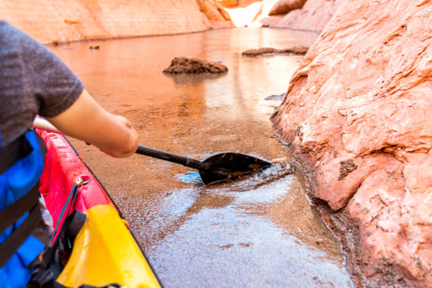 kayaking in lake powell narrow and shallow antelope canyon with man holding paddle oar by dirty muddy water and rock formations - 16607 imagens e fotografias de stock