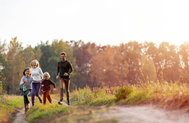 giovane famiglia che si diverte all'aperto - family with two children father clothing smiling foto e immagini stock