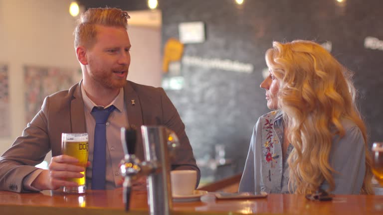 Young businessman in relaxed conversation with woman at the bar