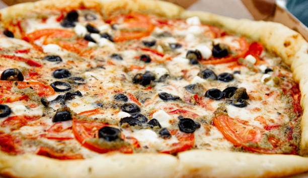 istock vegetarian pizza with olives, tomatoes and cheese. 1182909894