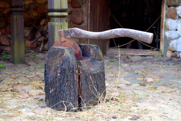 istock A big rusty executioner axe or hatchet with a massive curvy wooden handle and a sharp edge inside of a big wooden log next to some hay seen on a sunny summer day during a medieval fair in Poland 1182913950