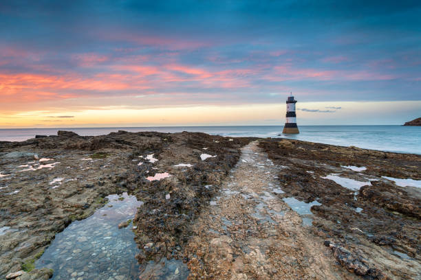 Trwyn Du Lighthouse at Penmon Point in Wales A beautiful sunset at Trwyn Du lighthouse on Penmon Point near Beaumaris on Anglesey in Wales gwynedd photos stock pictures, royalty-free photos & images