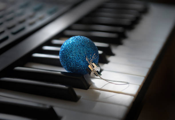istock A blue bauble is lying among the synthesizer keys. 1182915930
