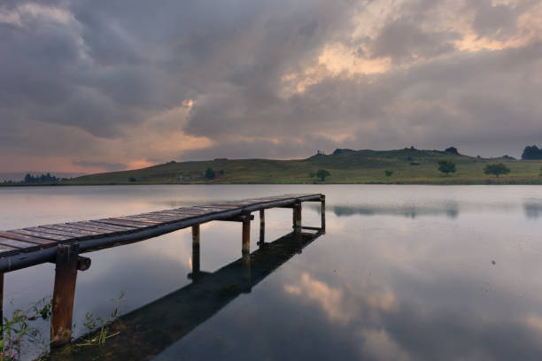 Landscape of a jetty on a dam with dramatic clouds of a rain storm stock photo