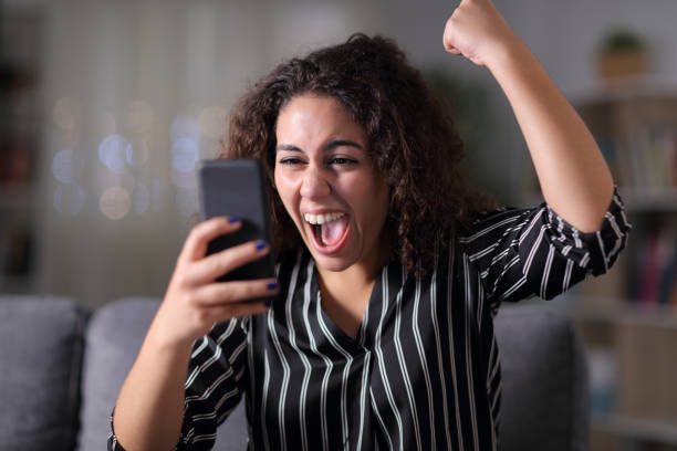 istock Excited woman checking mobile phone in the night 1182918450