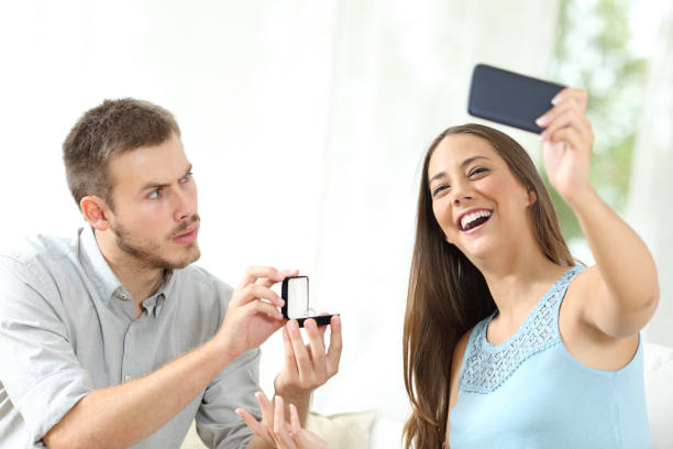 istock Upset man proposing marriage and girlfriend taking selfie 1182919121