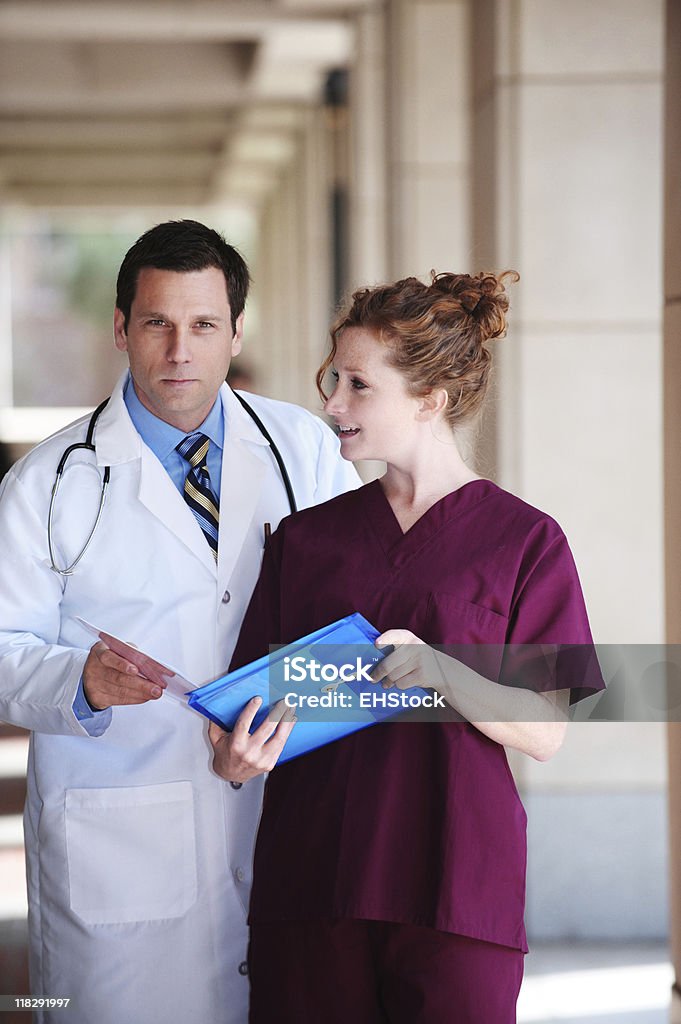 Médico y enfermera examinar paciente los registros médicos del Hospital clínica - Foto de stock de Adulto libre de derechos