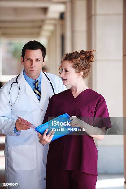 Médico Y Enfermera Examinar Paciente Los Registros Médicos Del Hospital Clínica Foto de stock y más banco de imágenes de Adulto