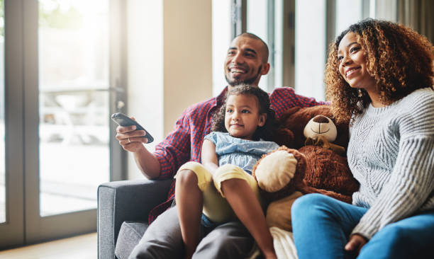 parece que tu programa favorito está en cariño - apartment television family couple fotografías e imágenes de stock