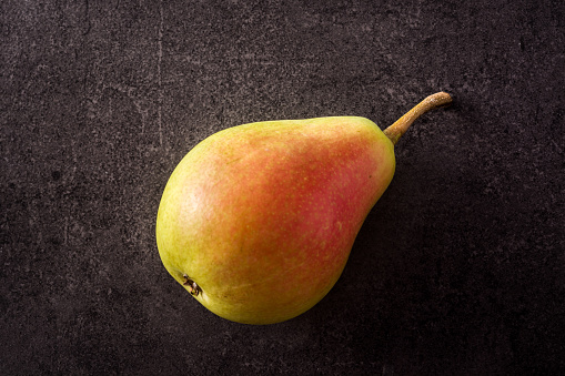 Pear on black slate background