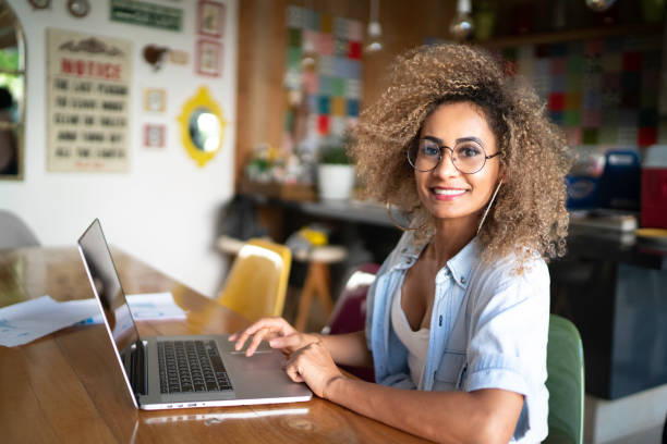 portret średniej dorosłej kobiety korzystającej z laptopa w domu - testimonial smiling women one person zdjęcia i obrazy z banku zdjęć