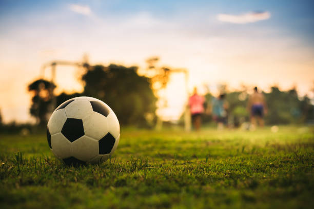 silhuoette esporte de ação ao ar livre de um grupo de crianças se divertindo jogando futebol de rua para o exercício na área rural da comunidade . crianças pobres e da pobreza no país do desenvolvimento. - playing the ball - fotografias e filmes do acervo