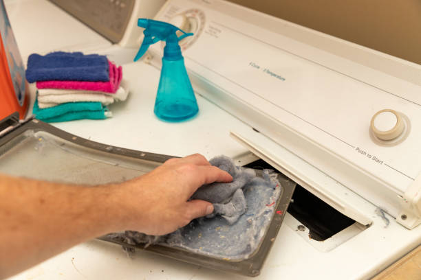 istock Hand cleaning dirty lint trap while doing laundry 1182931971