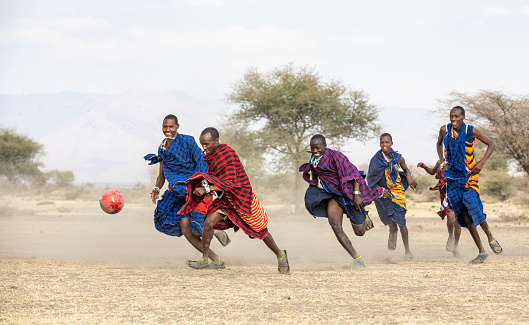 Arusha, Tanzania, 7th September 2019: maasai warriors playing football in savannah