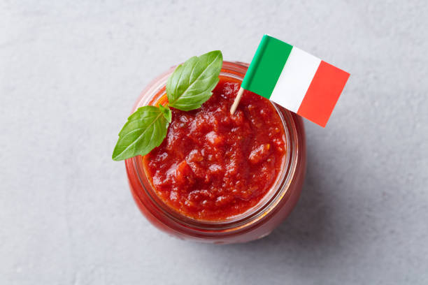 tomato sauce with basil in a glass jar with italian flag. grey background. top view. close up. - restaurant pasta italian culture dinner imagens e fotografias de stock