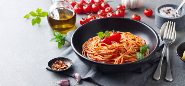istock Pasta, spaghetti with tomato sauce in black bowl on grey background. Copy space. 1182932911