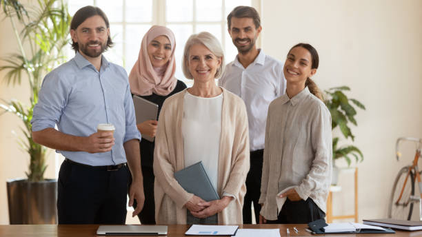 istock Happy multicultural team with old leader stand look at camera 1182933957