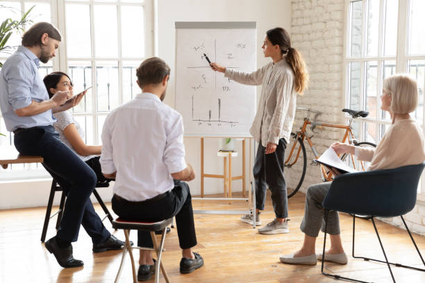istock Serious young female manager coach give presentation at corporate workshop 1182934079