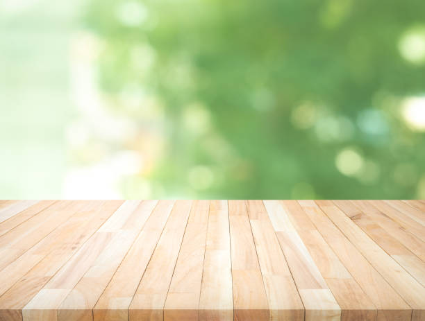 istock Empty wood table top on blur abstract green garden from window view 1182934528