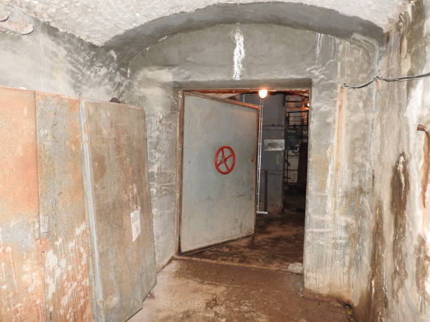 istock An abandoned prison in an underground bunker. A former Soviet cold war bomb shelter. The sealed door of the bunker. Pipes and valves. Low light condition. Bunker of fear and nightmares. 1182934597