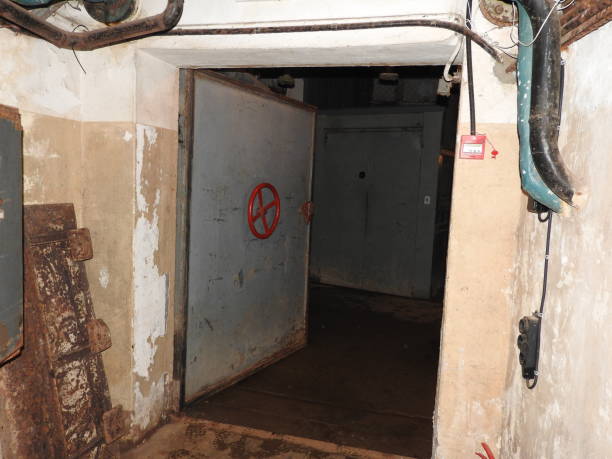 istock An abandoned prison in an underground bunker. A former Soviet cold war bomb shelter. The sealed door of the bunker. Pipes and valves. Low light condition. Bunker of fear and nightmares. 1182934925