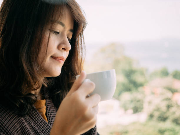 istock Young woman having coffee at home 1182935888