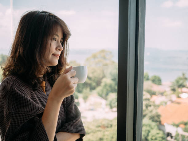 istock Young woman having coffee at home 1182935890