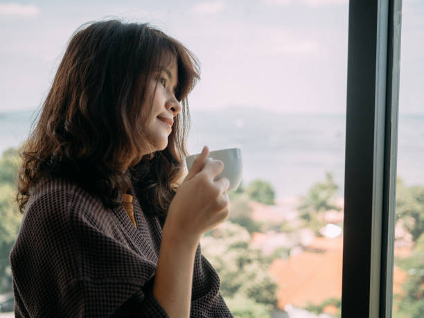 istock Young woman having coffee at home 1182935904