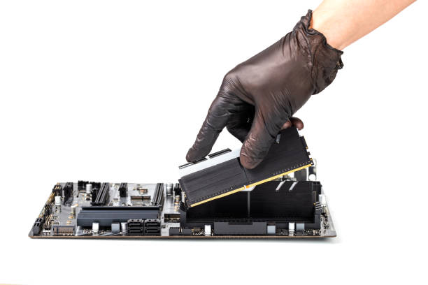 hand in black glove installing memory module with heatsink in pc motherboard isolated on white background