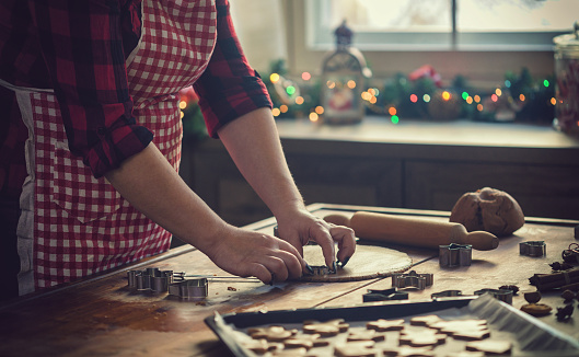 Young mother preparing gingerbread cookies for the Christmas at home