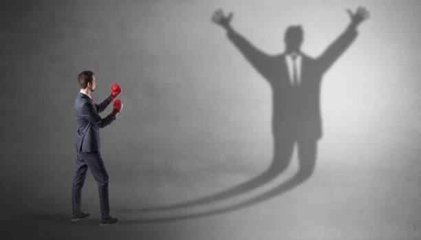 istock Businessman fighting with a disarmed businessman shadow 1182939063