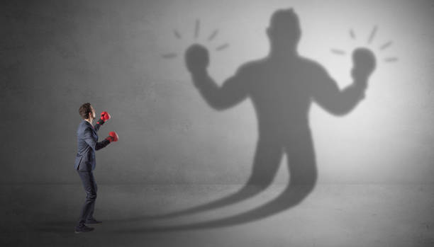 istock Businessman fighting with his unarmed shadow 1182939285