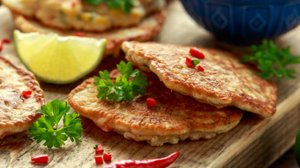 istock Corn fritters, pancake with dip white sauce, lime and chilli on wooden board 1182939687