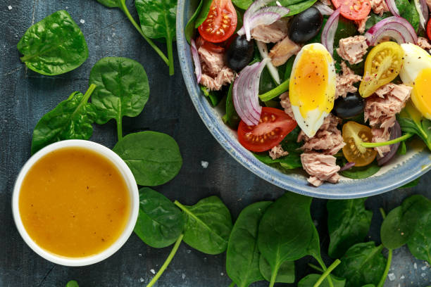 istock Protein packed tuna and soft, runny egg salad with pear shaped cherry tomatoes, black olives and spinach 1182939804