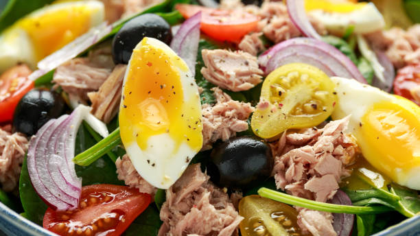 istock Protein packed tuna and soft, runny egg salad with pear shaped cherry tomatoes, black olives and spinach 1182940000