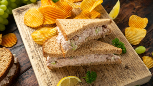 Healthy Tuna Sandwich with celery and onion on wooden board Healthy Tuna Sandwich with celery and onion on wooden board. tarragon cutting board vegetable herb stock pictures, royalty-free photos & images