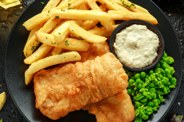 istock British Traditional Fish and chips with mashed peas, tartar sauce and cold beer. 1182940076