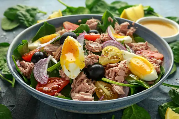 Photo of Protein packed tuna and soft, runny egg salad with pear shaped cherry tomatoes, black olives and spinach