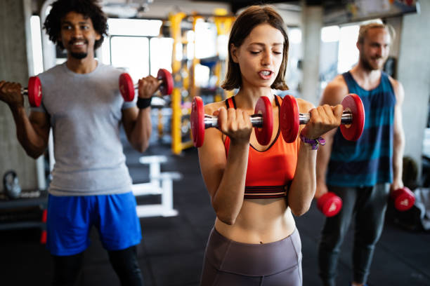 istock Group of young people doing exercises in gym 1182941545