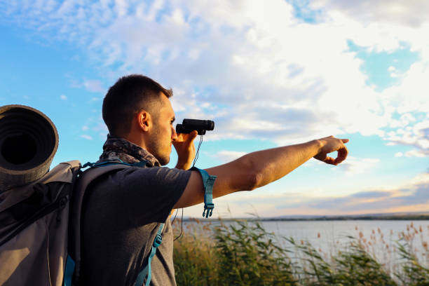 istock young traveler man watching nature with binoculars traveler looking away through binoculars. 1182941995