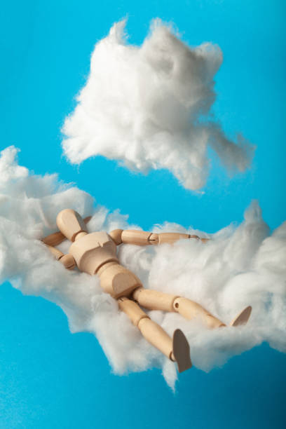istock Napping toy man on comfortable cloud bed. Relax and dream 1182942041