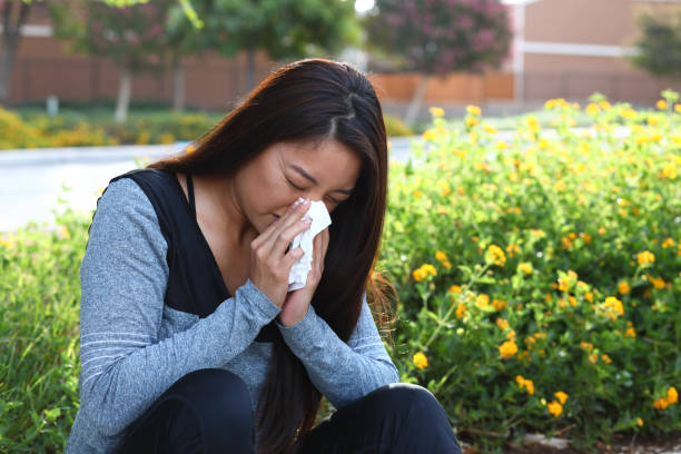 istock Allergy Woman Blows Nose Gray Top Left 1182944444