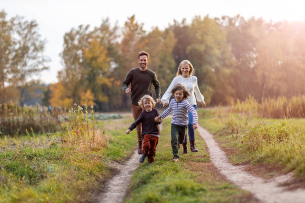 giovane famiglia che si diverte all'aperto - family with two children father clothing smiling foto e immagini stock