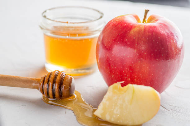 apple slice dipped in honey stock photo